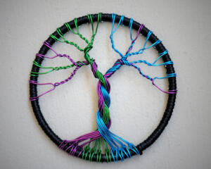 dark rainnbow colors make this little tree of life stand out in the crowd. The hoop is wrapped with black silk cord.